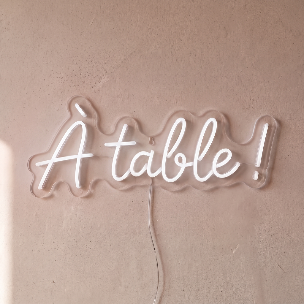 Néon mural « À table ! » blanc, gros plan sur fond beige