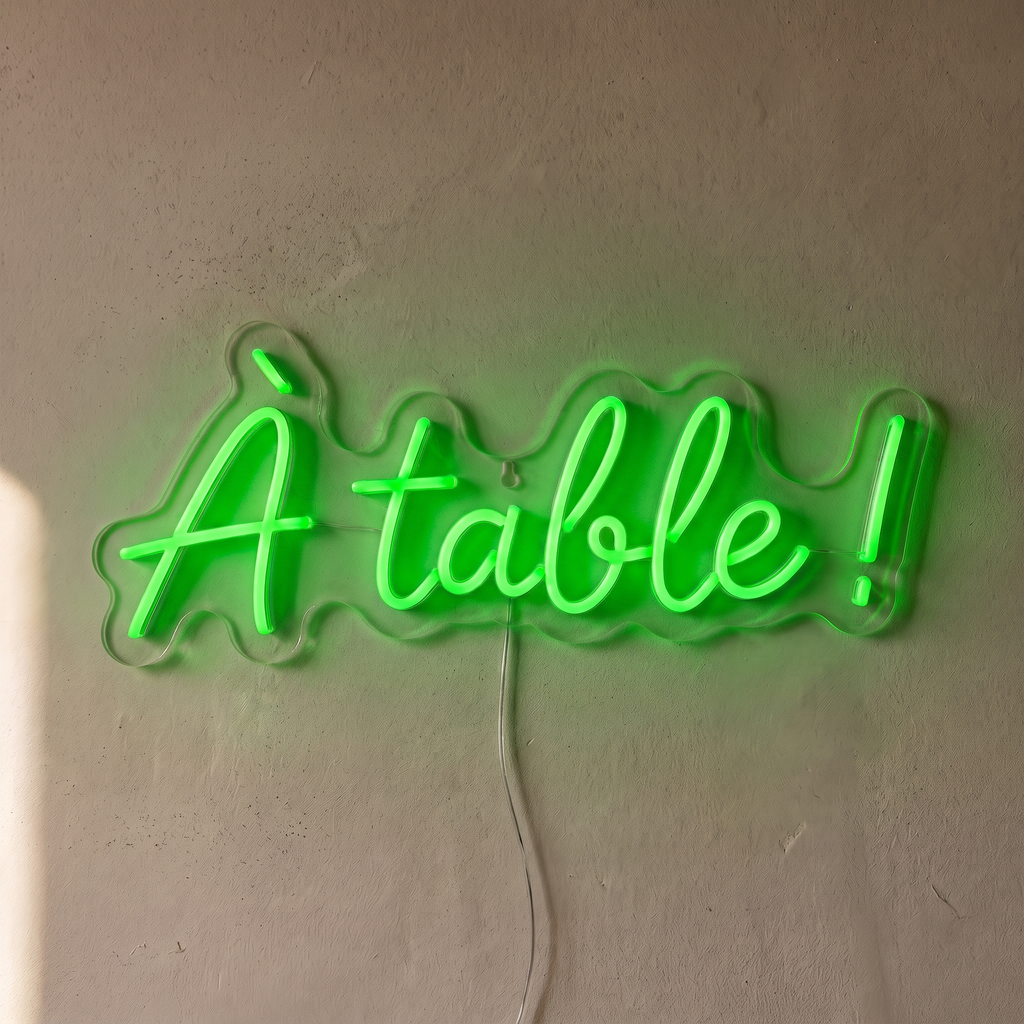 Néon mural « À table ! » vert, gros plan sur fond beige
