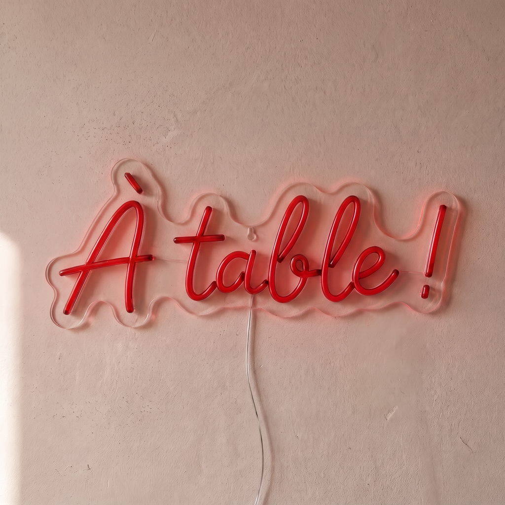 Néon mural « À table ! » rouge, gros plan sur fond beige