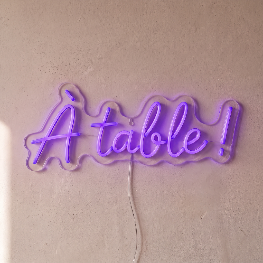 Néon mural « À table ! » violet, gros plan sur fond beige