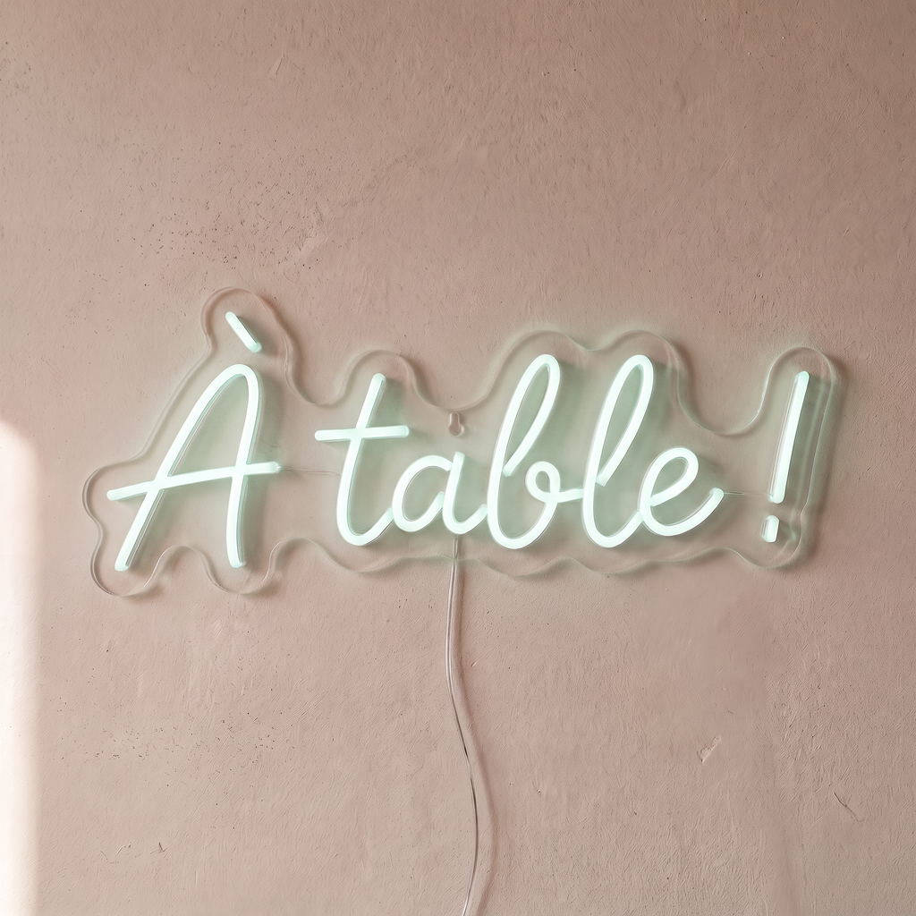 Néon mural « À table ! » blanc froid, gros plan sur fond beige