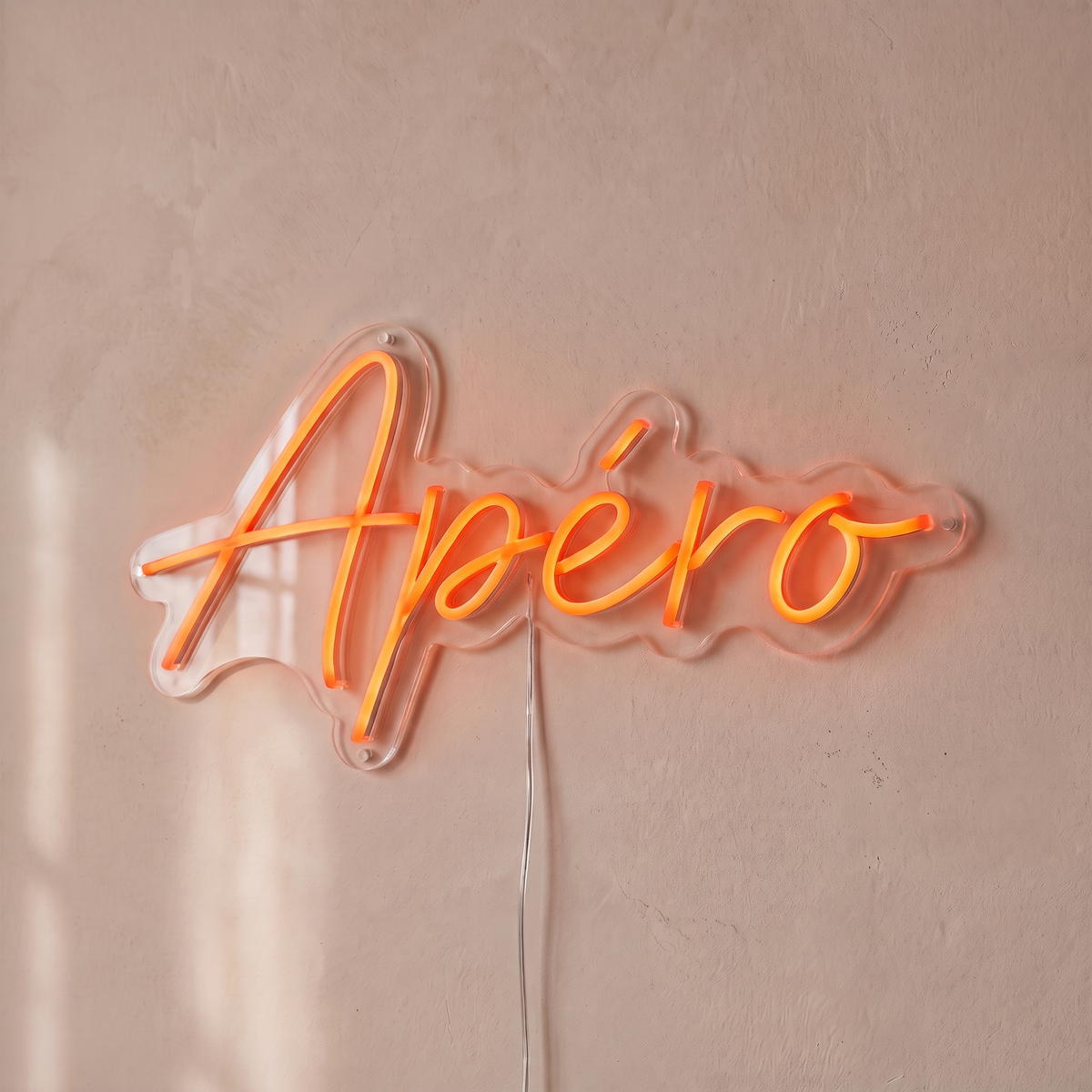 Néon mural « Apéro » rouge orangé, gros plan sur fond beige