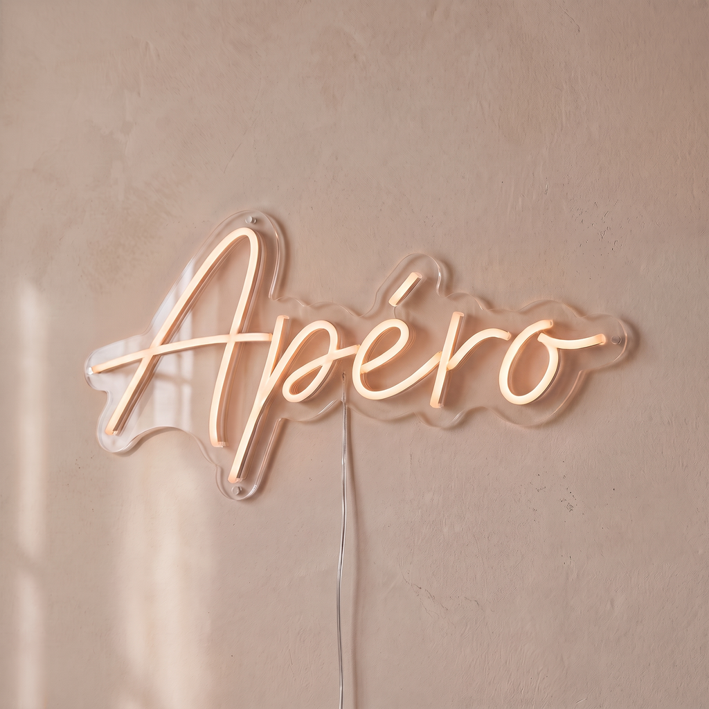 Néon mural « Apéro » rose pâle, gros plan sur fond beige
