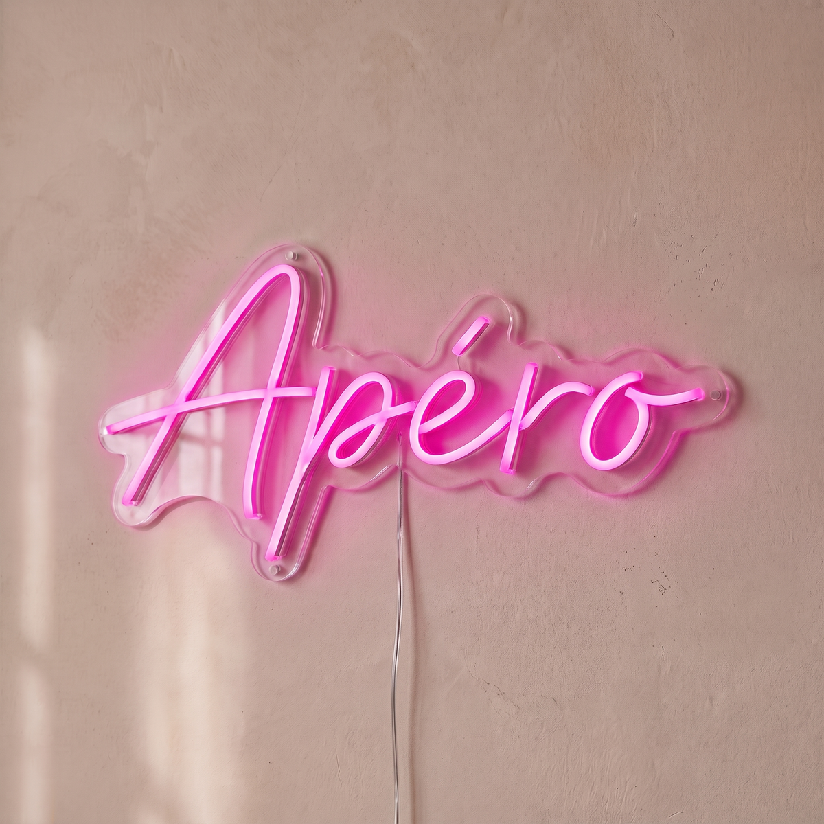 Néon mural « Apéro » rose, gros plan sur fond beige