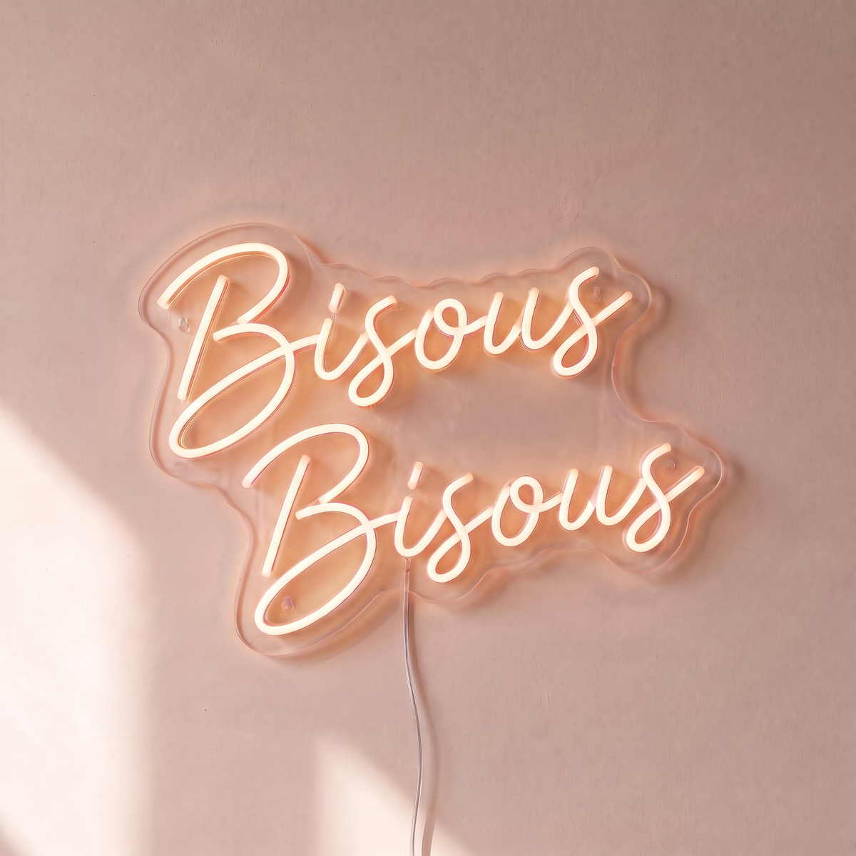 Néon mural « Bisous Bisous » blanc chaud, gros plan sur fond beige