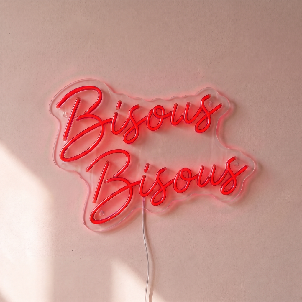 Néon mural « Bisous Bisous » rouge, gros plan sur fond beige