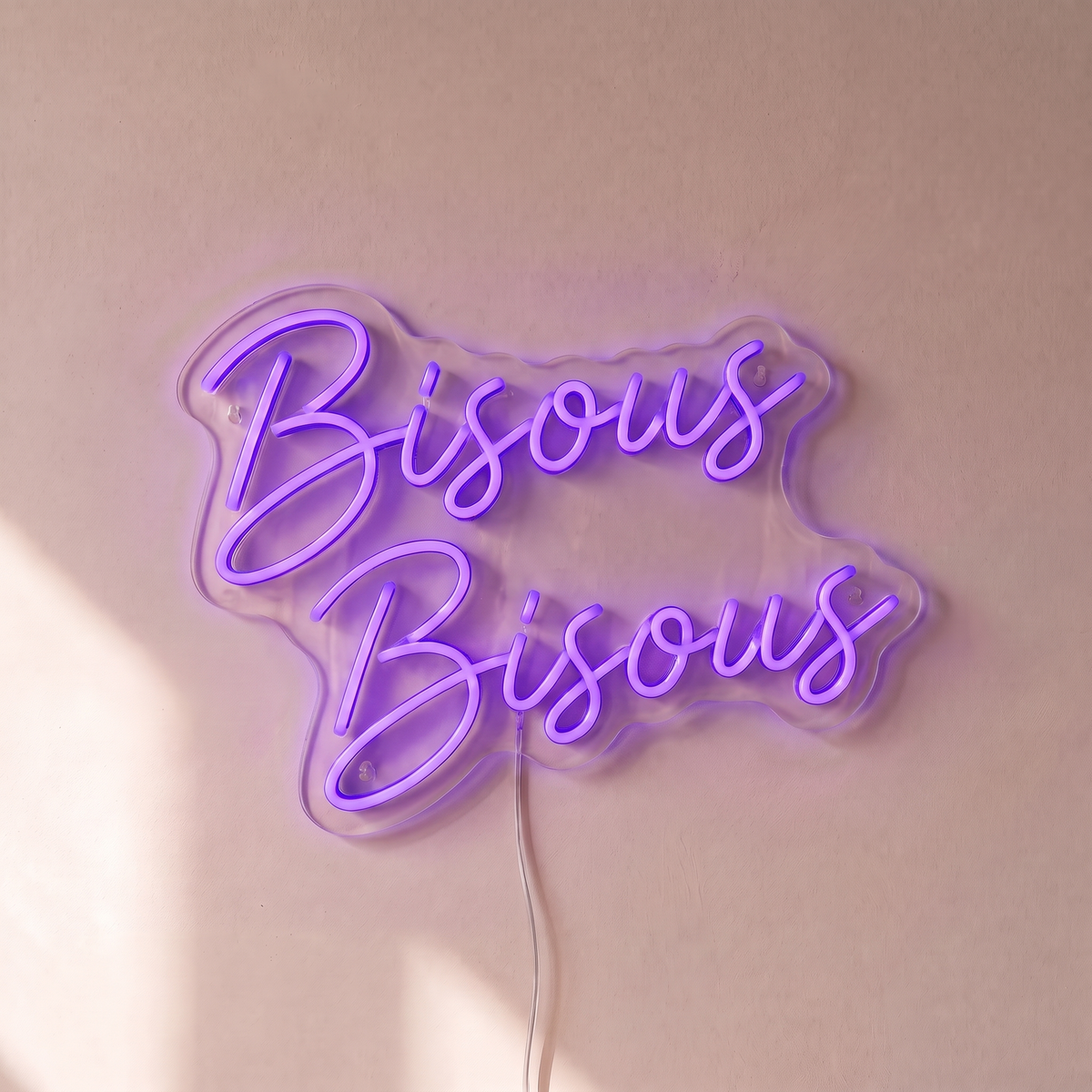 Néon mural « Bisous Bisous » violet, gros plan sur fond beige
