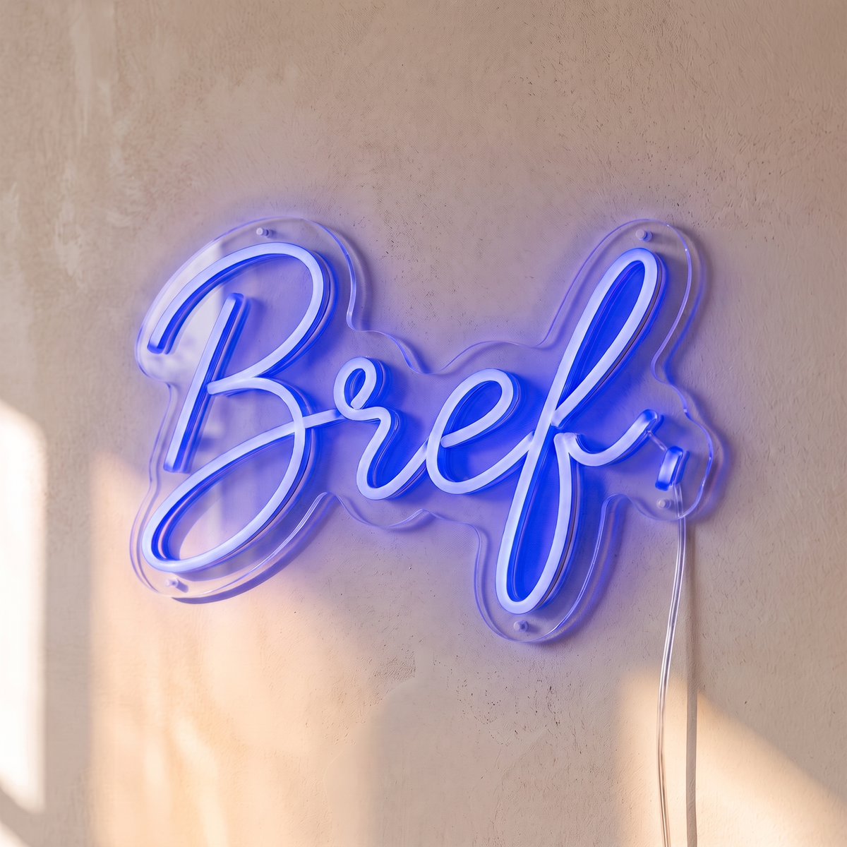 Néon mural « Bref. » bleu, gros plan sur fond beige