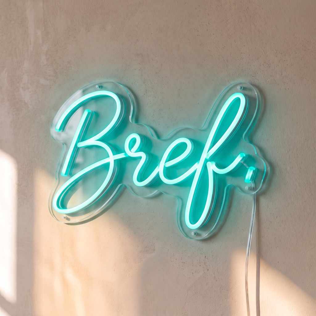 Néon mural « Bref. » turquoise, gros plan sur fond beige