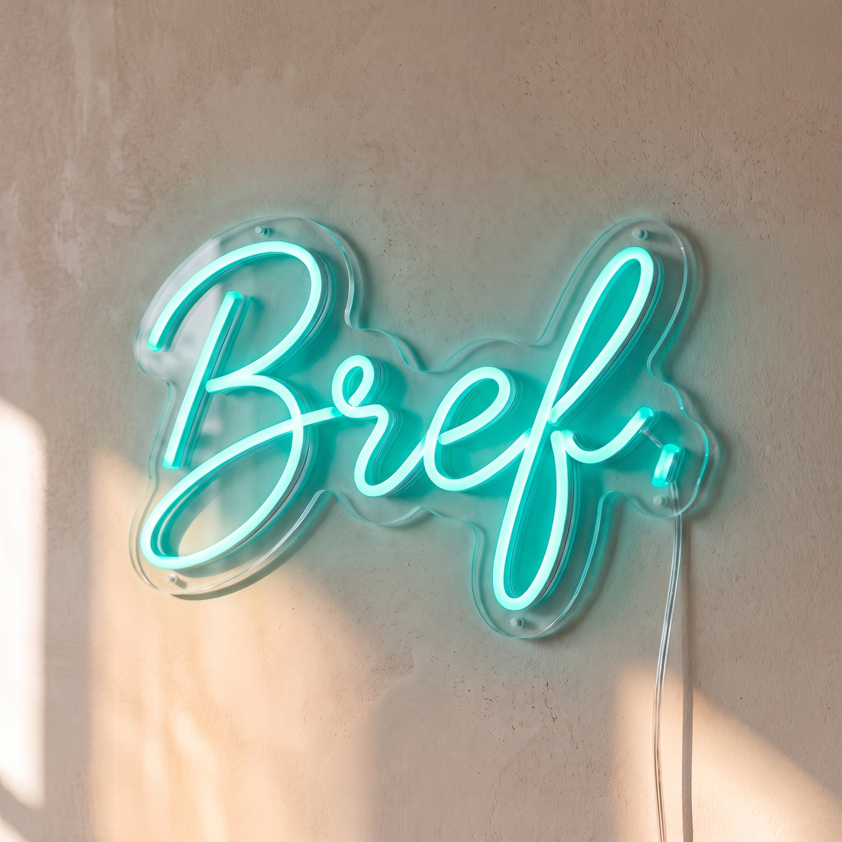 Néon mural « Bref. » turquoise, gros plan sur fond beige
