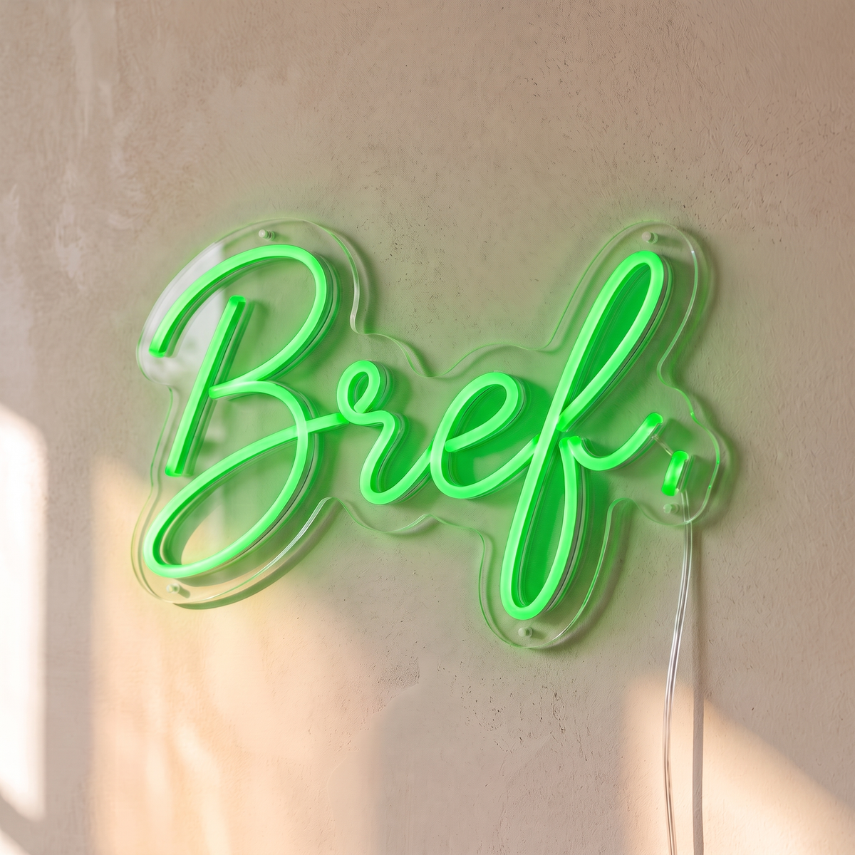 Néon mural « Bref. » vert, gros plan sur fond beige