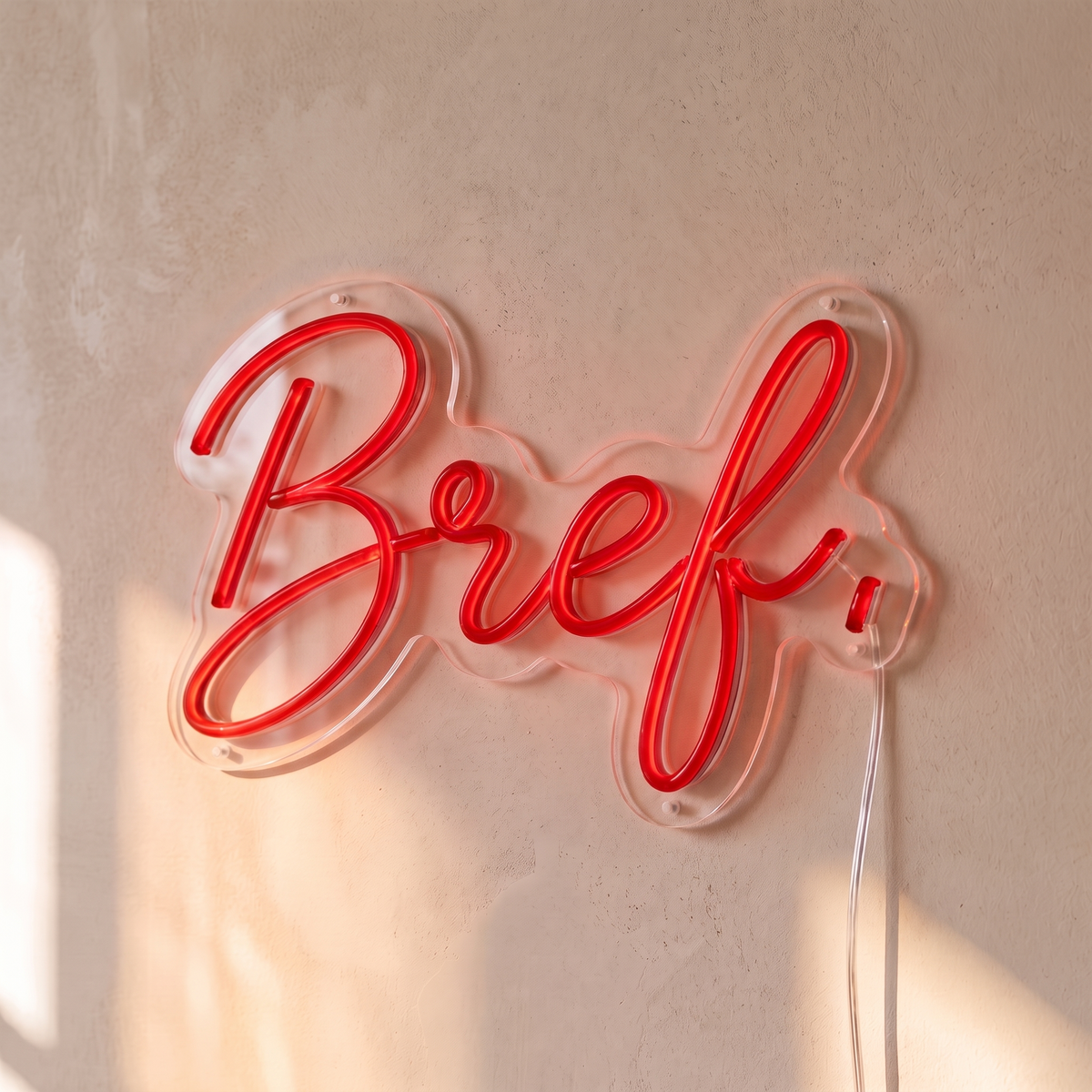 Néon mural « Bref. » rouge, gros plan sur fond beige