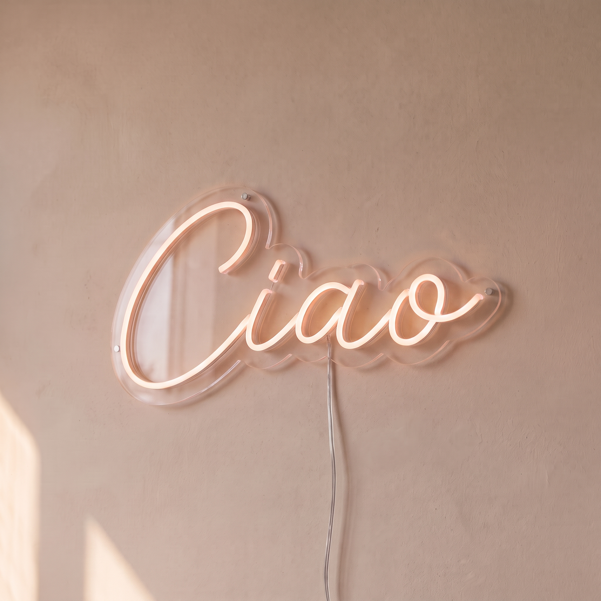 Néon mural « Ciao » blanc chaud, gros plan sur fond beige