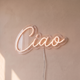 Néon mural « Ciao » blanc chaud, gros plan sur fond beige