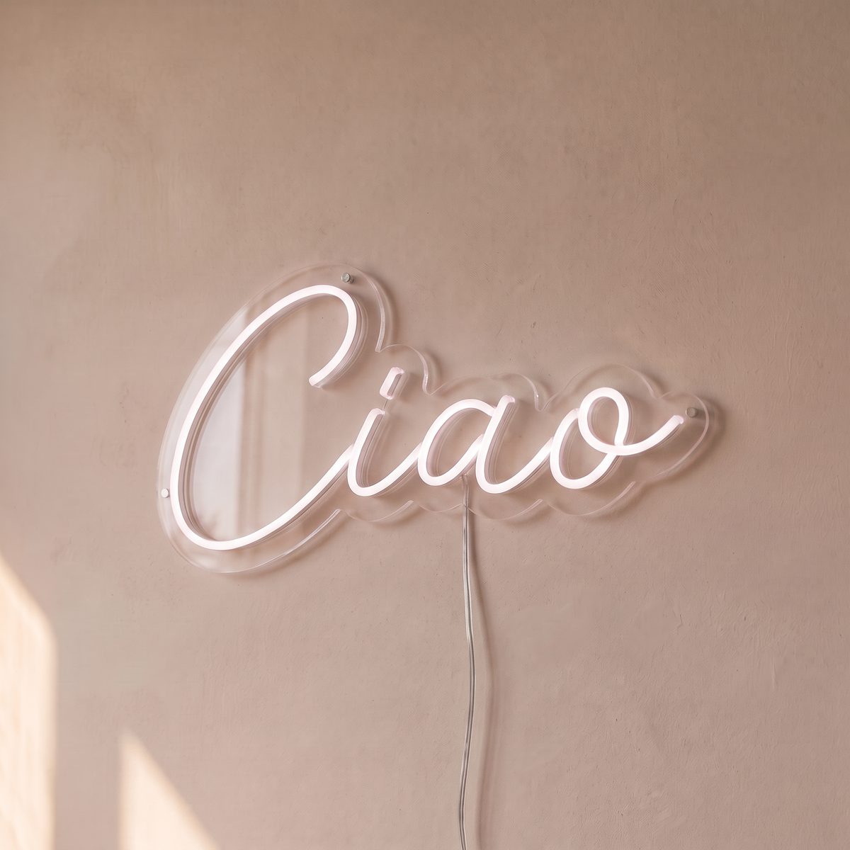 Néon mural « Ciao » blanc, gros plan sur fond beige