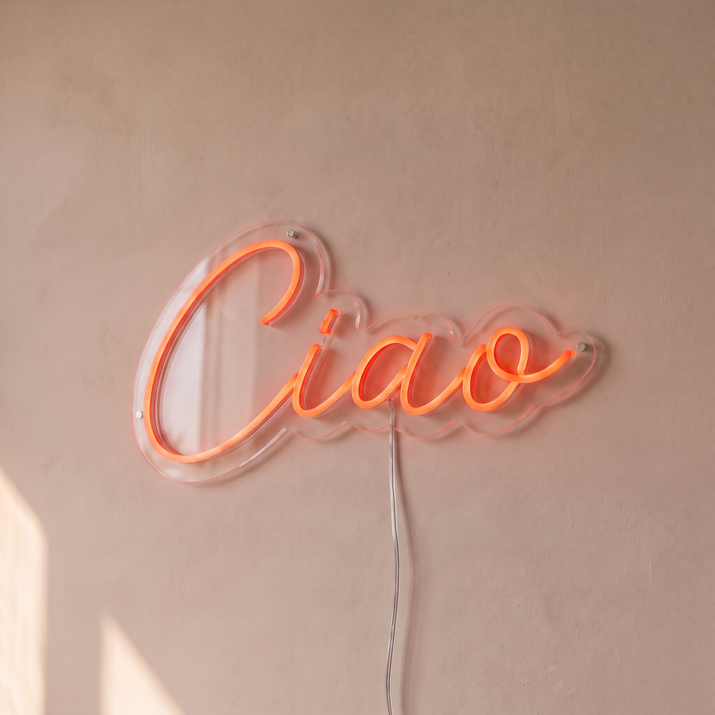 Néon mural « Ciao » rouge orangé, gros plan sur fond beige