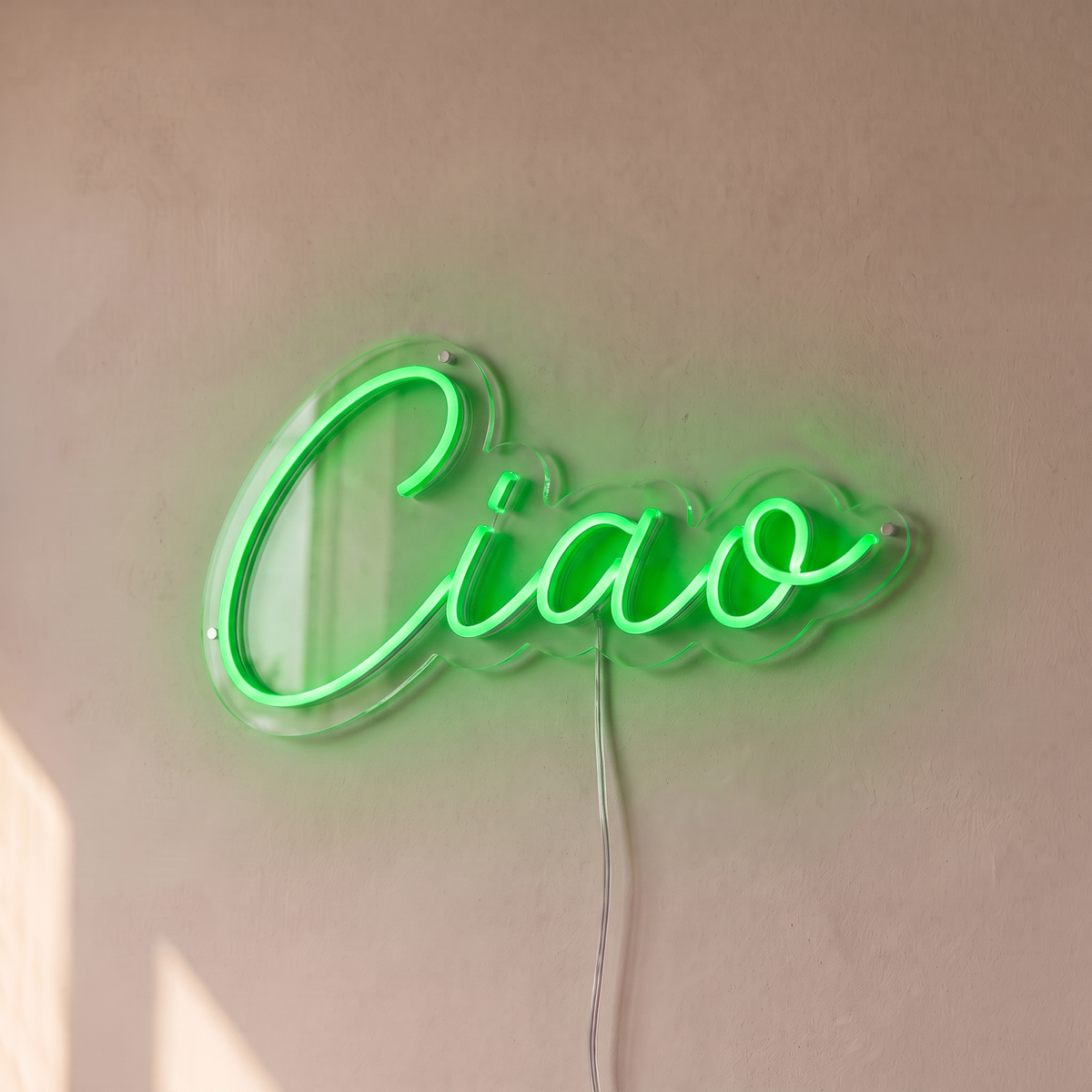 Néon mural « Ciao » vert, gros plan sur fond beige