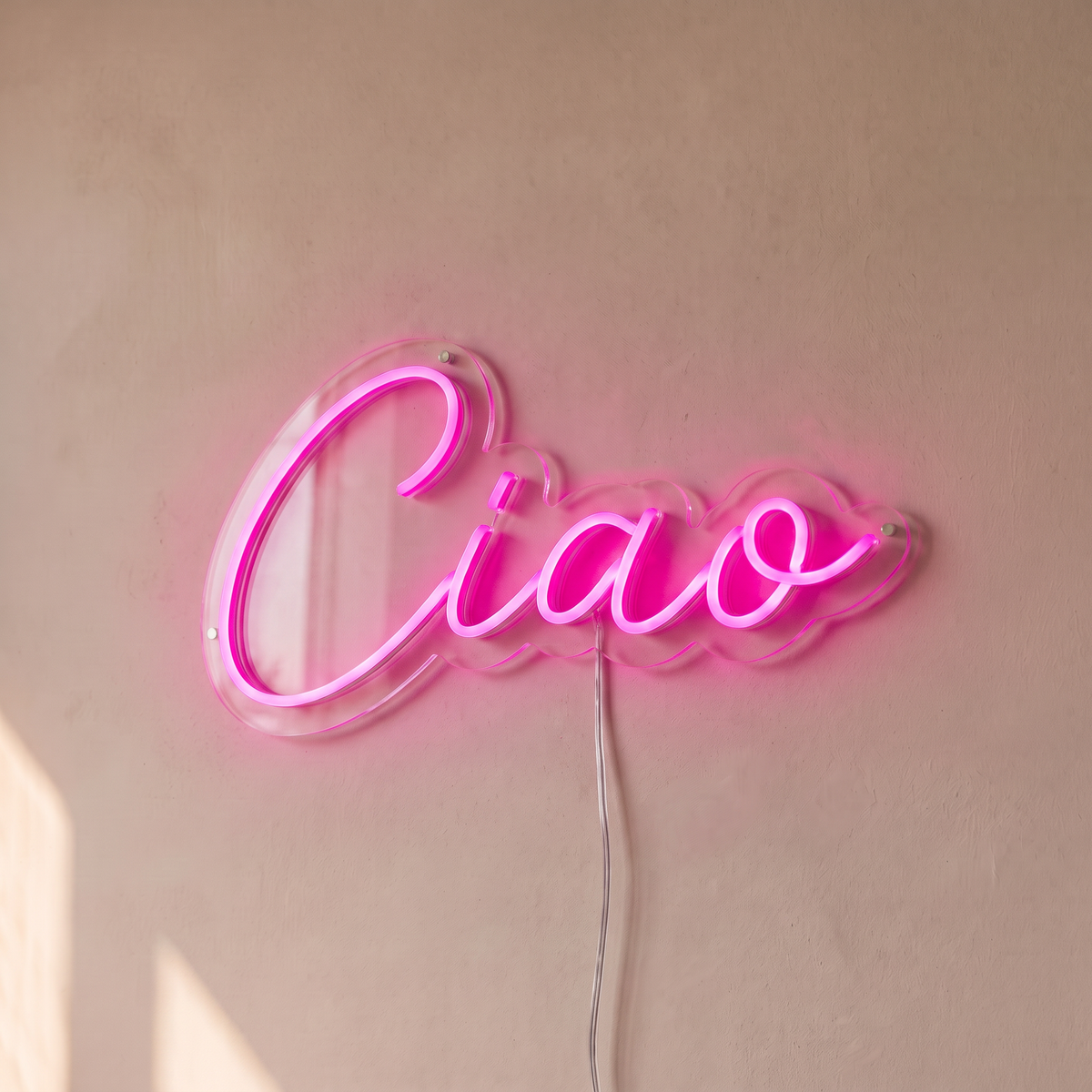 Néon mural « Ciao » rose, gros plan sur fond beige
