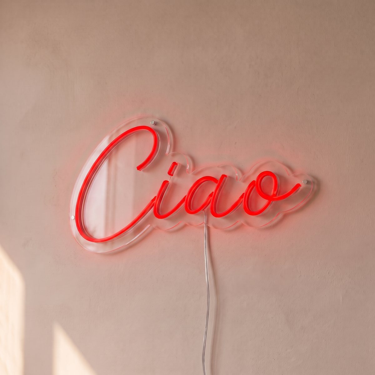 Néon mural « Ciao » rouge, gros plan sur fond beige