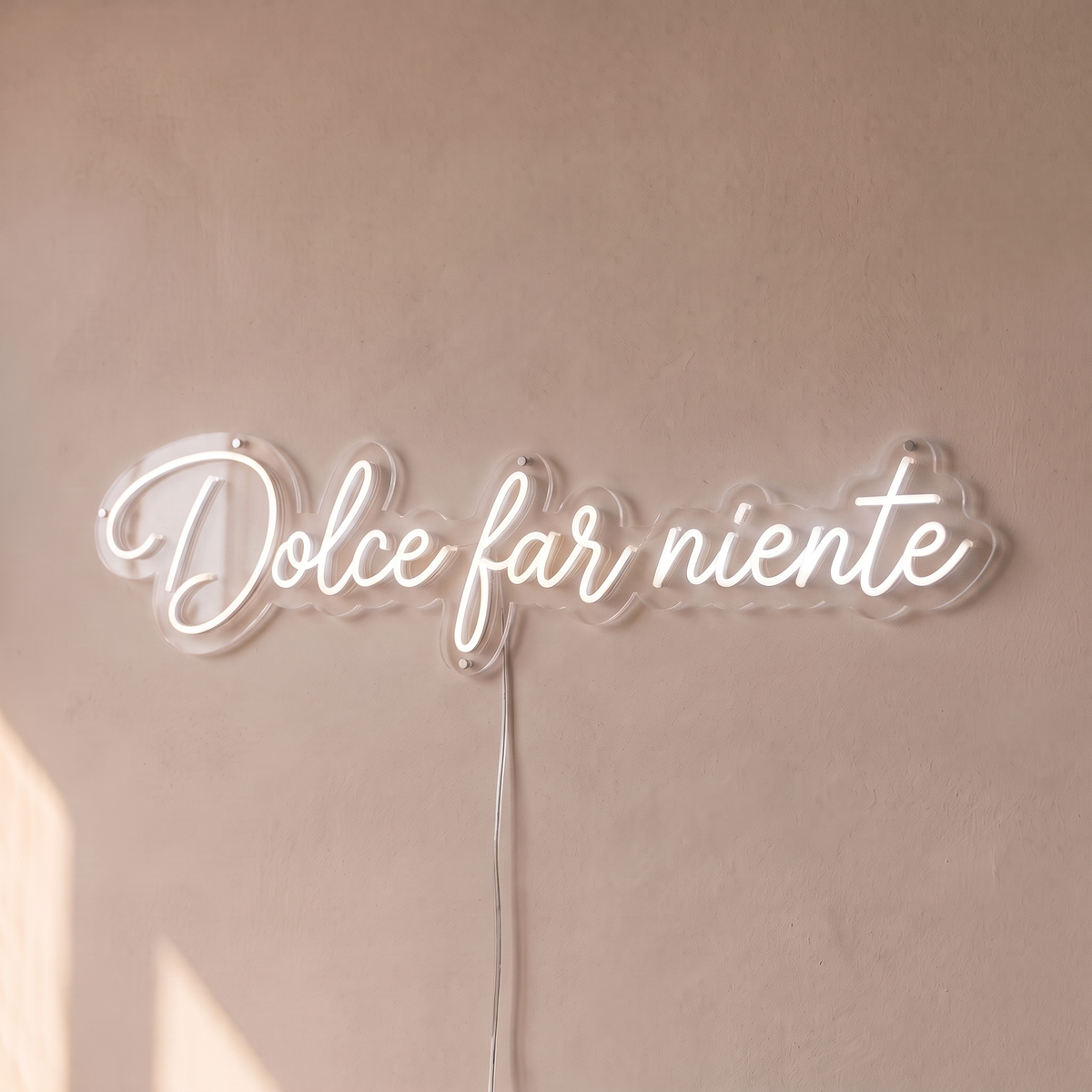 Néon mural « Dolce far niente » blanc, gros plan sur fond beige