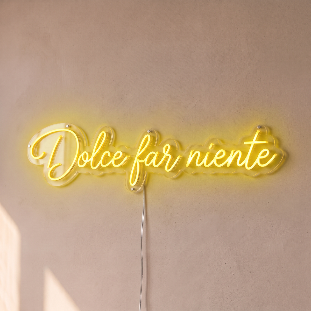 Néon mural « Dolce far niente » jaune, gros plan sur fond beige
