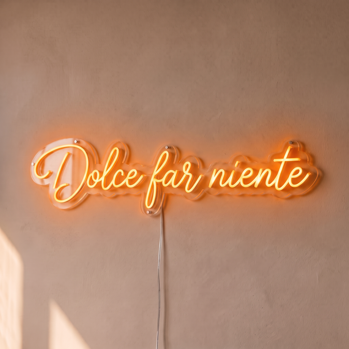 Néon mural « Dolce far niente » orange, gros plan sur fond beige