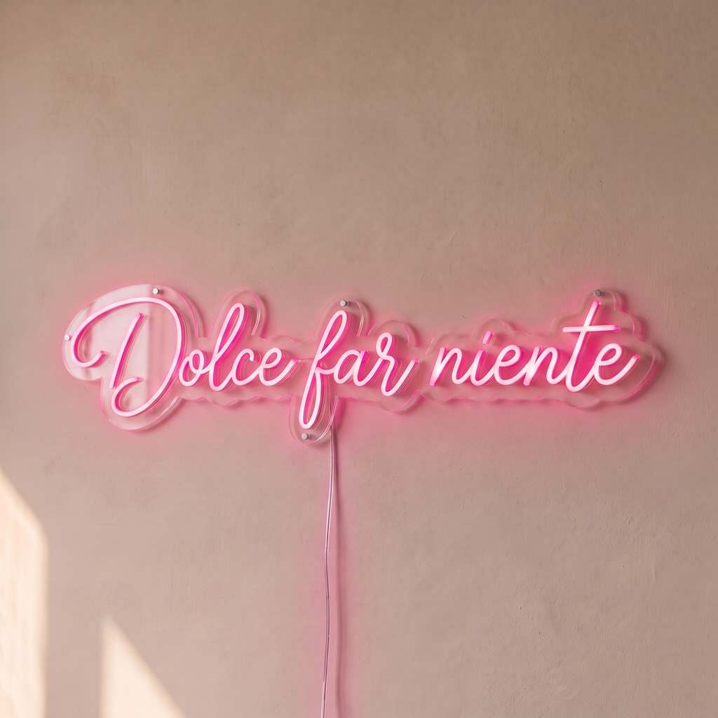 Néon mural « Dolce far niente » rose, gros plan sur fond beige