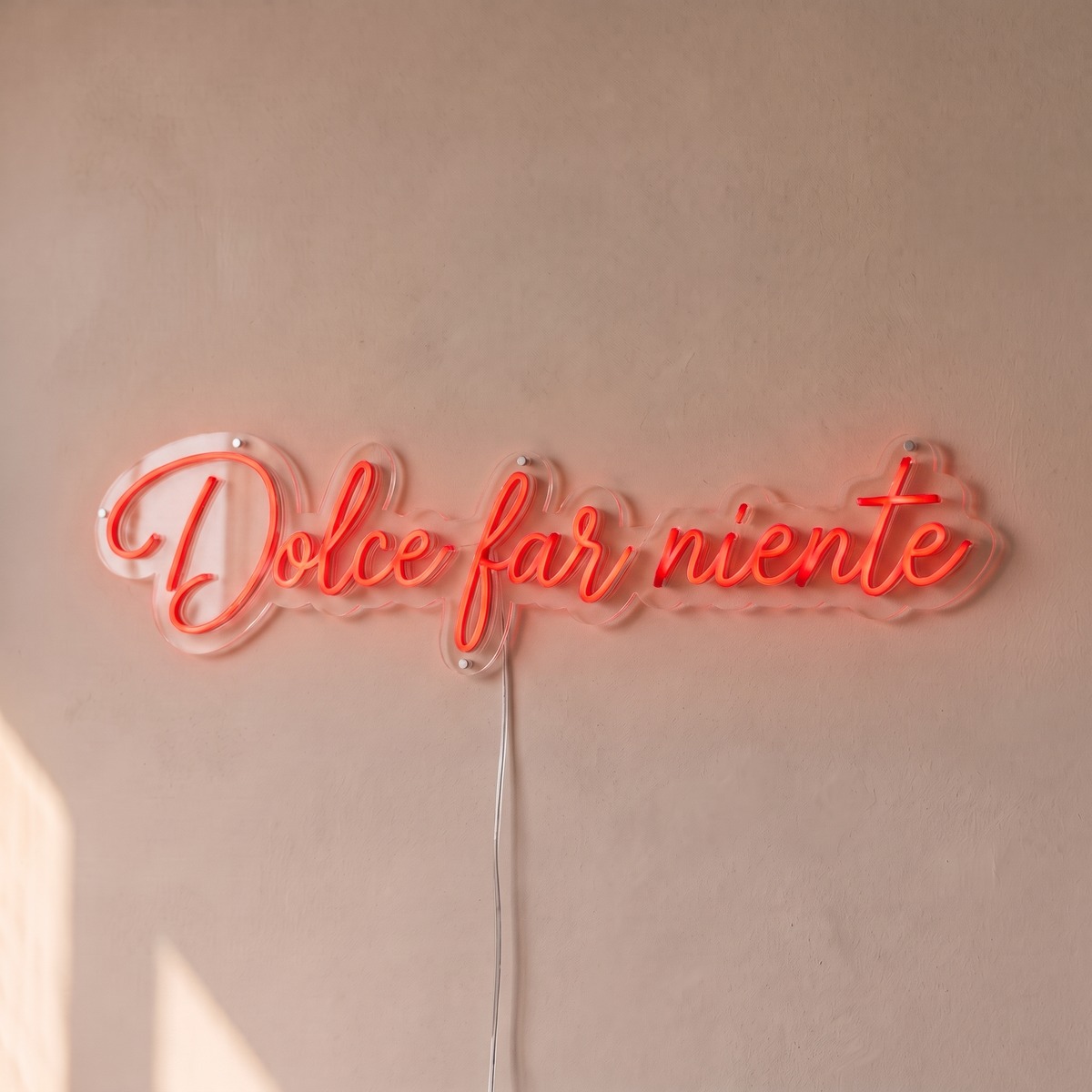 Néon mural « Dolce far niente » rouge, gros plan sur fond beige