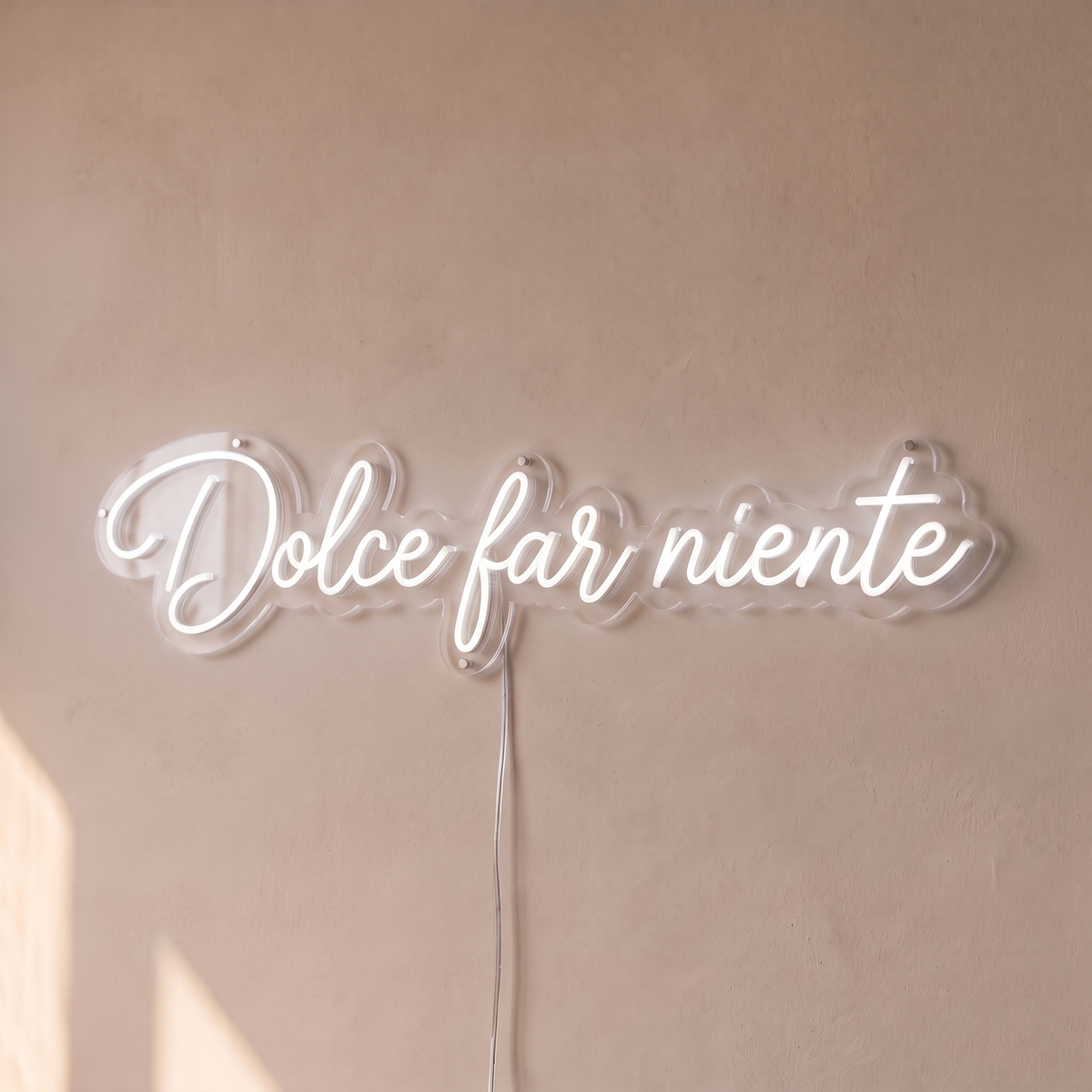 Néon mural « Dolce far niente » blanc froid, gros plan sur fond beige