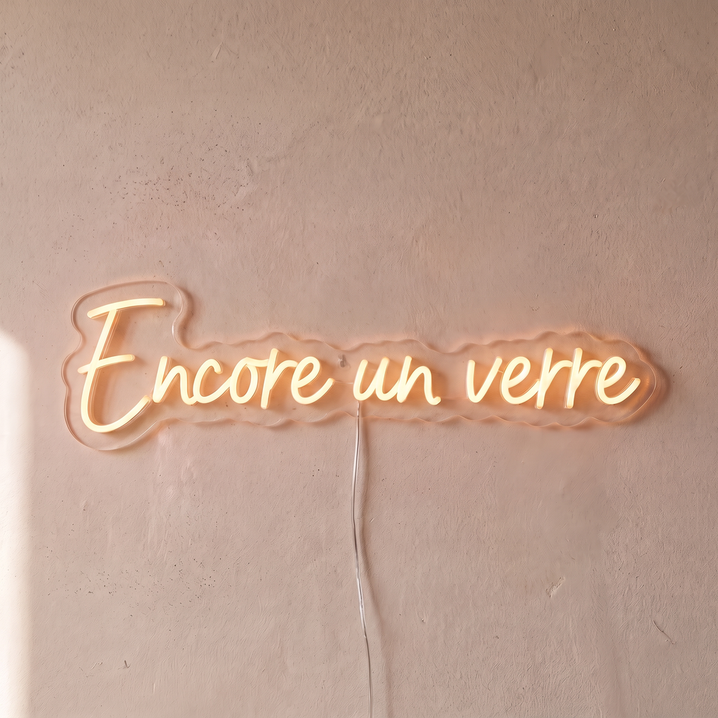 Néon mural « Encore un verre » blanc chaud, gros plan sur fond beige