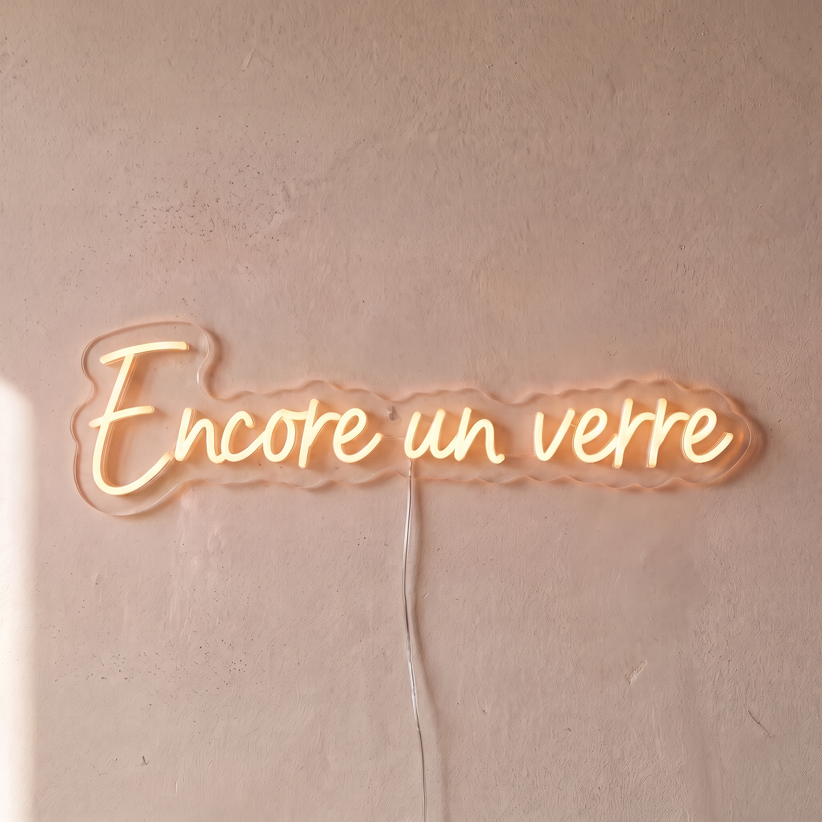 Néon mural « Encore un verre » blanc chaud, gros plan sur fond beige
