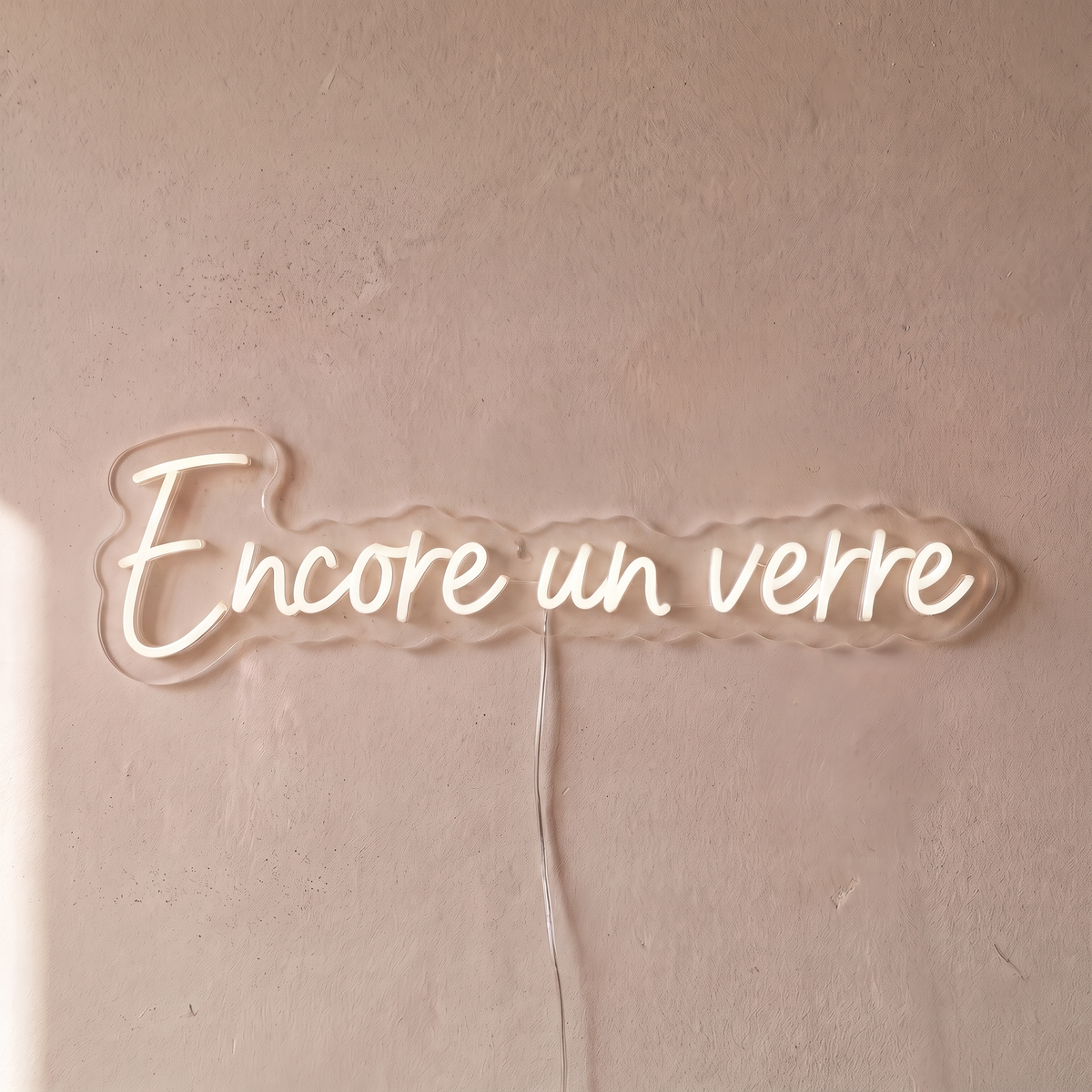 Néon mural « Encore un verre » blanc, gros plan sur fond beige