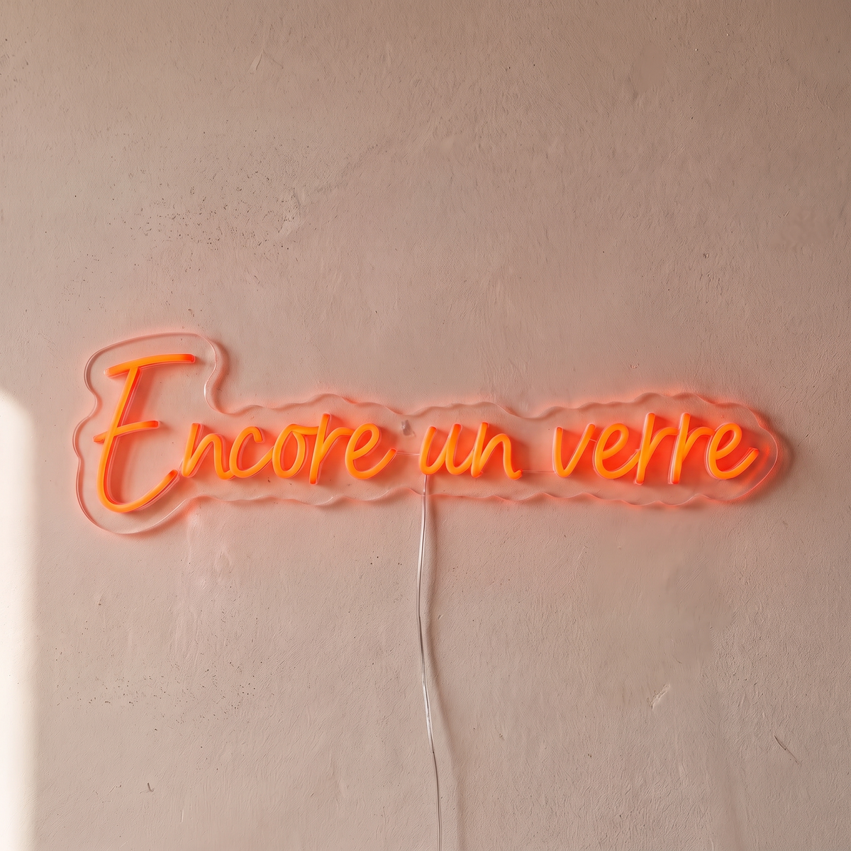 Néon mural « Encore un verre » rouge orangé, gros plan sur fond beige