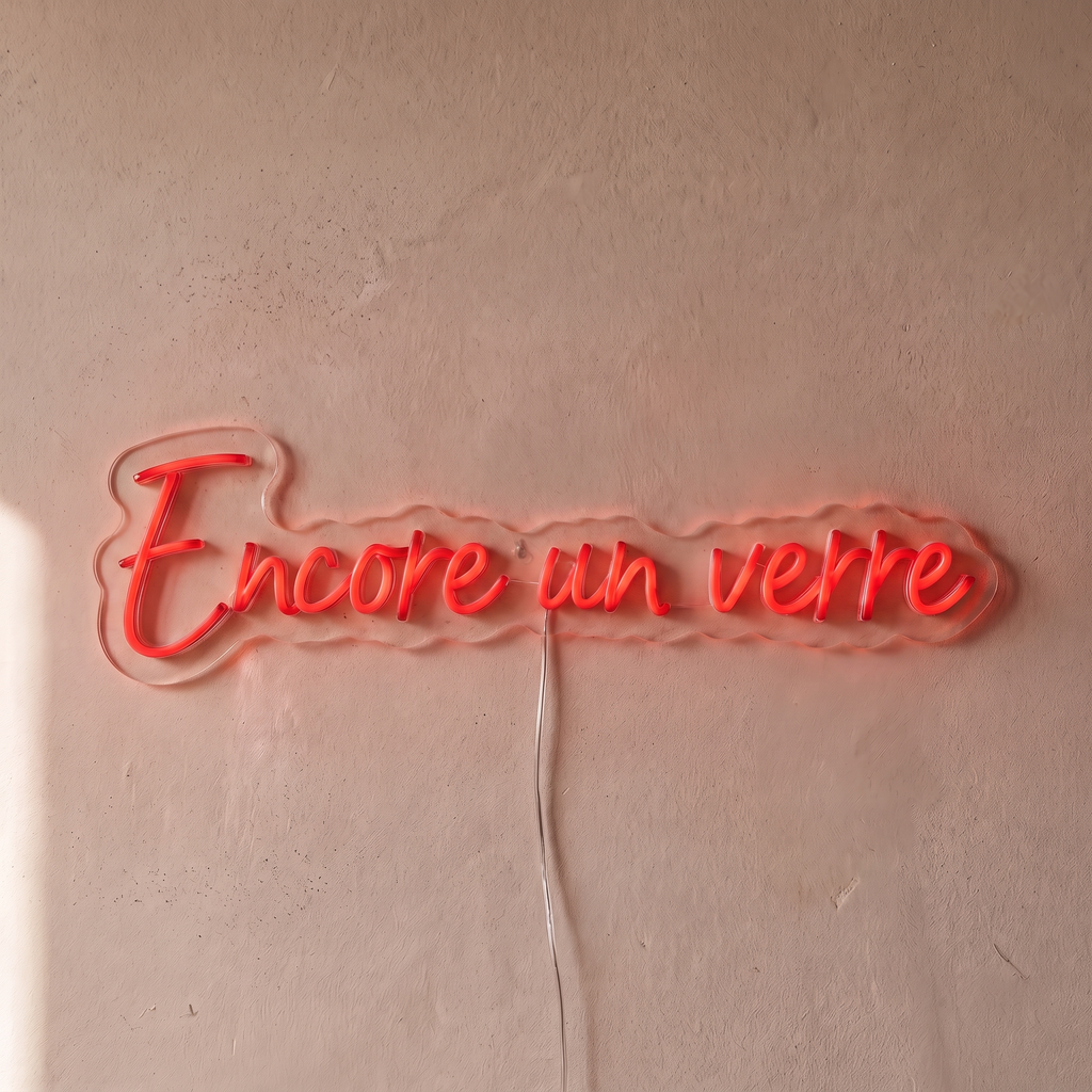 Néon mural « Encore un verre » rouge, gros plan sur fond beige