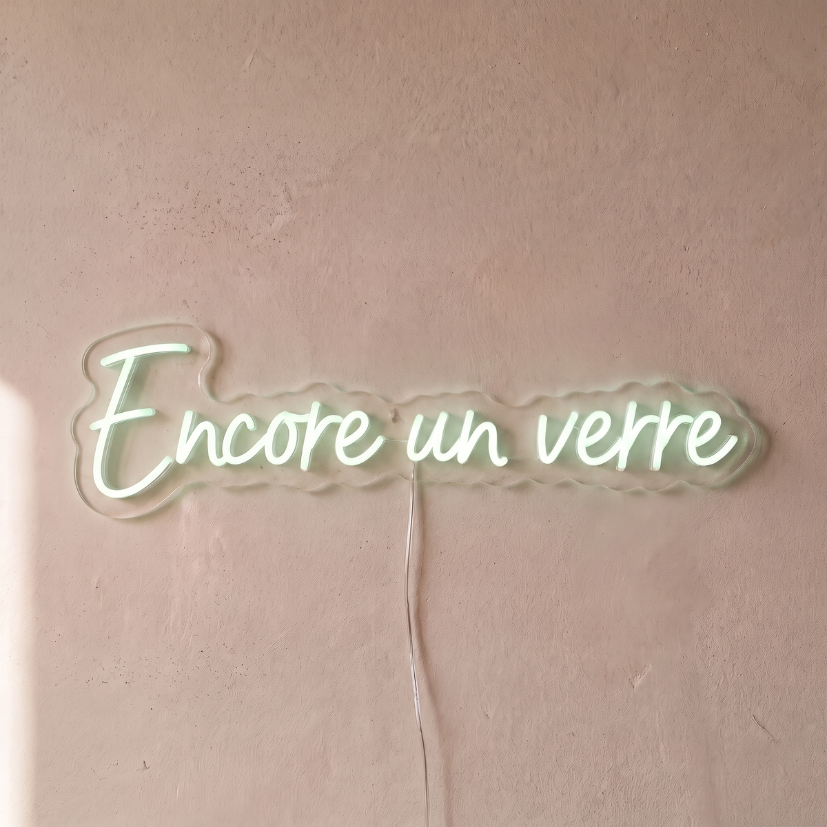 Néon mural « Encore un verre » blanc froid, gros plan sur fond beige