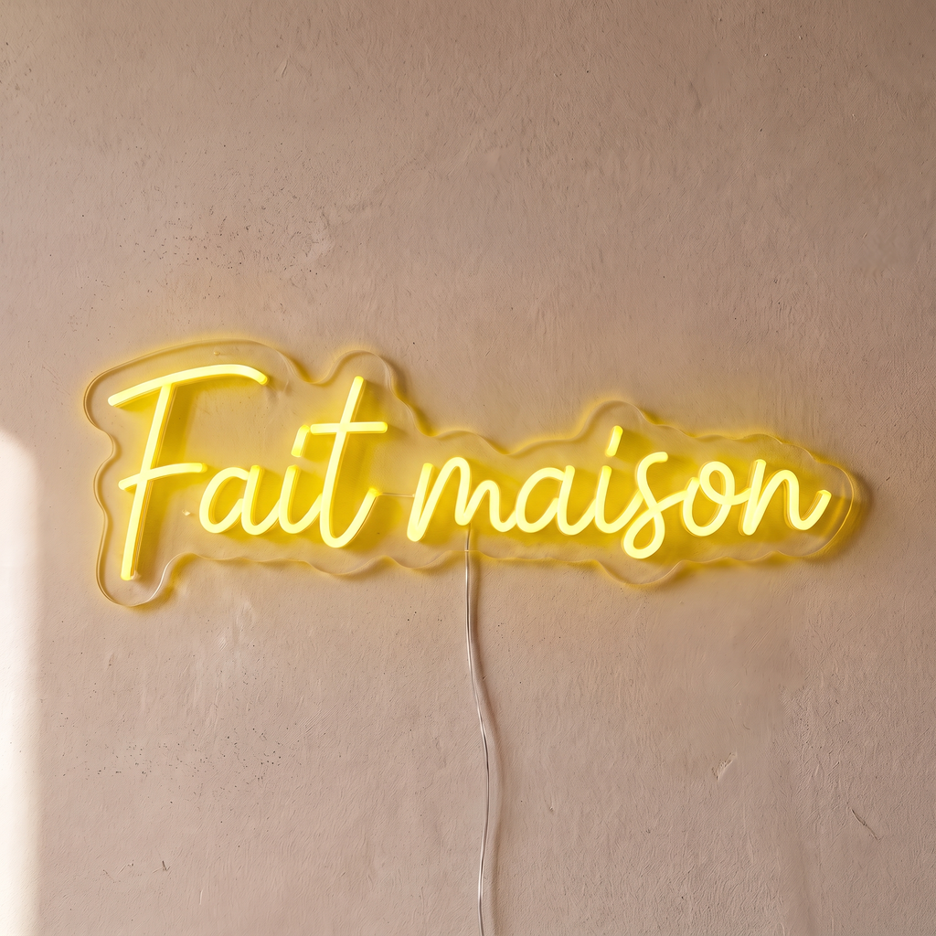 Néon mural « Fait maison » jaune, gros plan sur fond beige