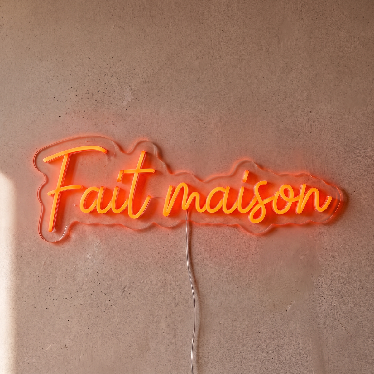 Néon mural « Fait maison » rouge orangé, gros plan sur fond beige