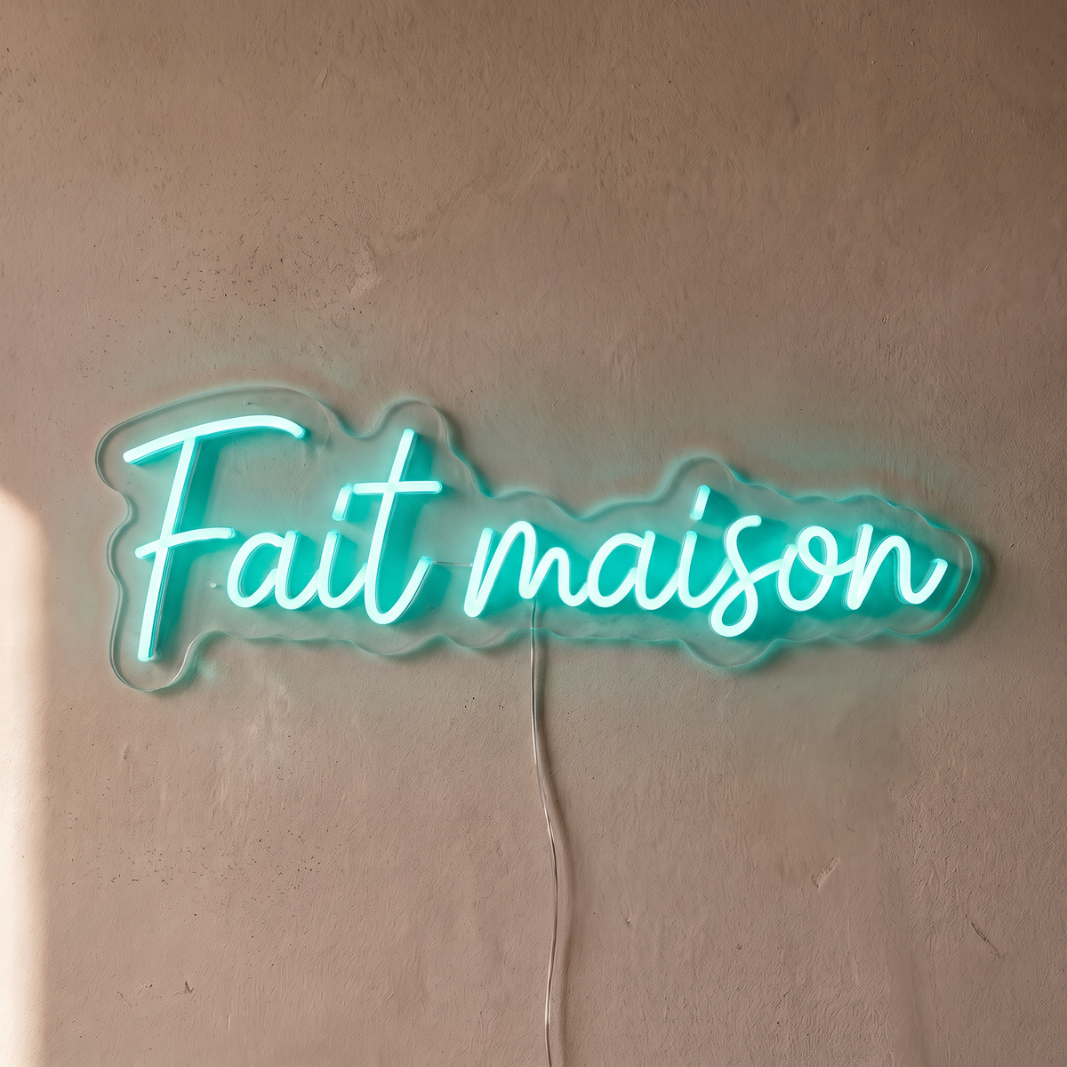 Néon mural « Fait maison » turquoise, gros plan sur fond beige