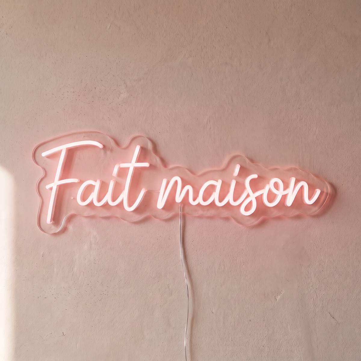 Néon mural « Fait maison » rose pâle, gros plan sur fond beige