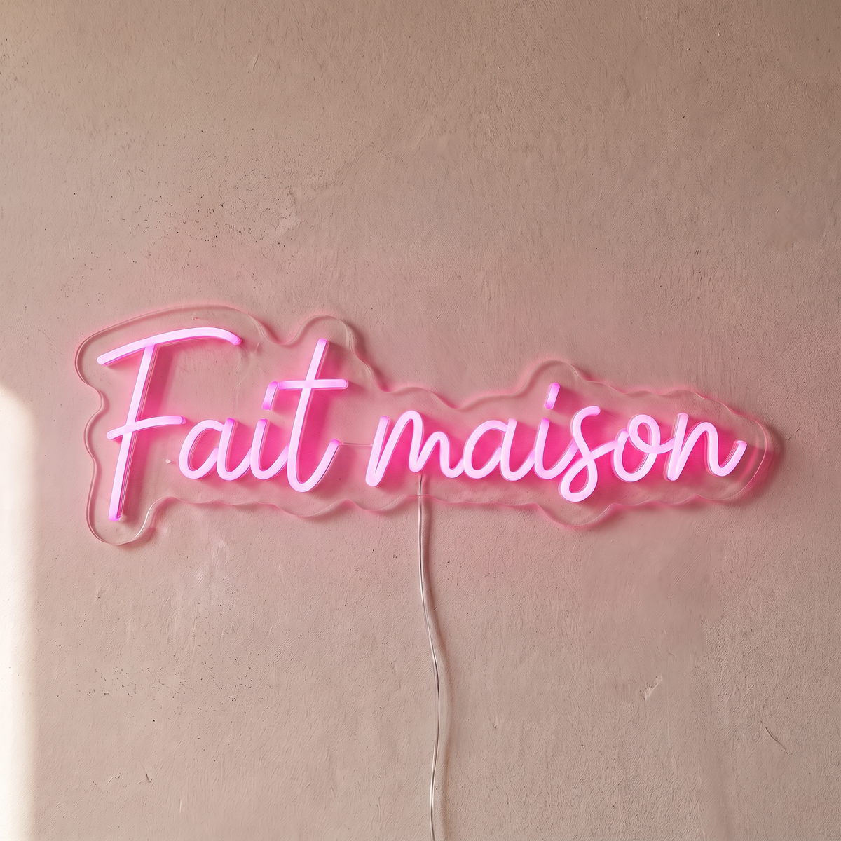 Néon mural « Fait maison » rose, gros plan sur fond beige