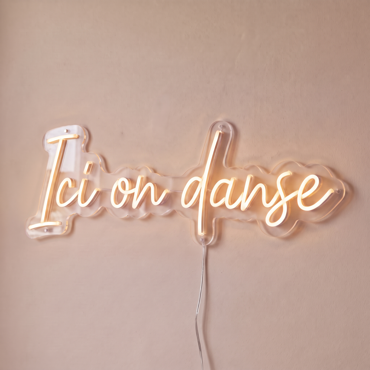 Néon mural « Ici on danse » blanc chaud, gros plan sur fond beige