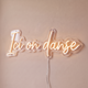 Néon mural « Ici on danse » blanc chaud, gros plan sur fond beige