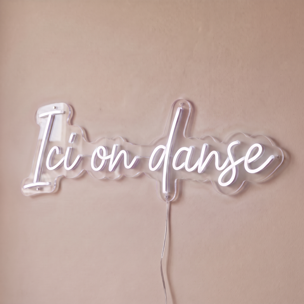 Néon mural « Ici on danse » blanc, gros plan sur fond beige