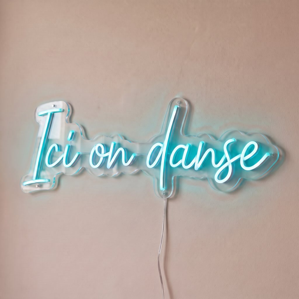 Néon mural « Ici on danse » turquoise, gros plan sur fond beige