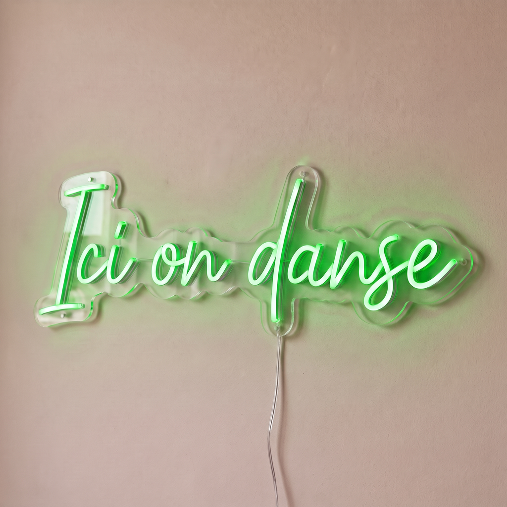 Néon mural « Ici on danse » vert, gros plan sur fond beige