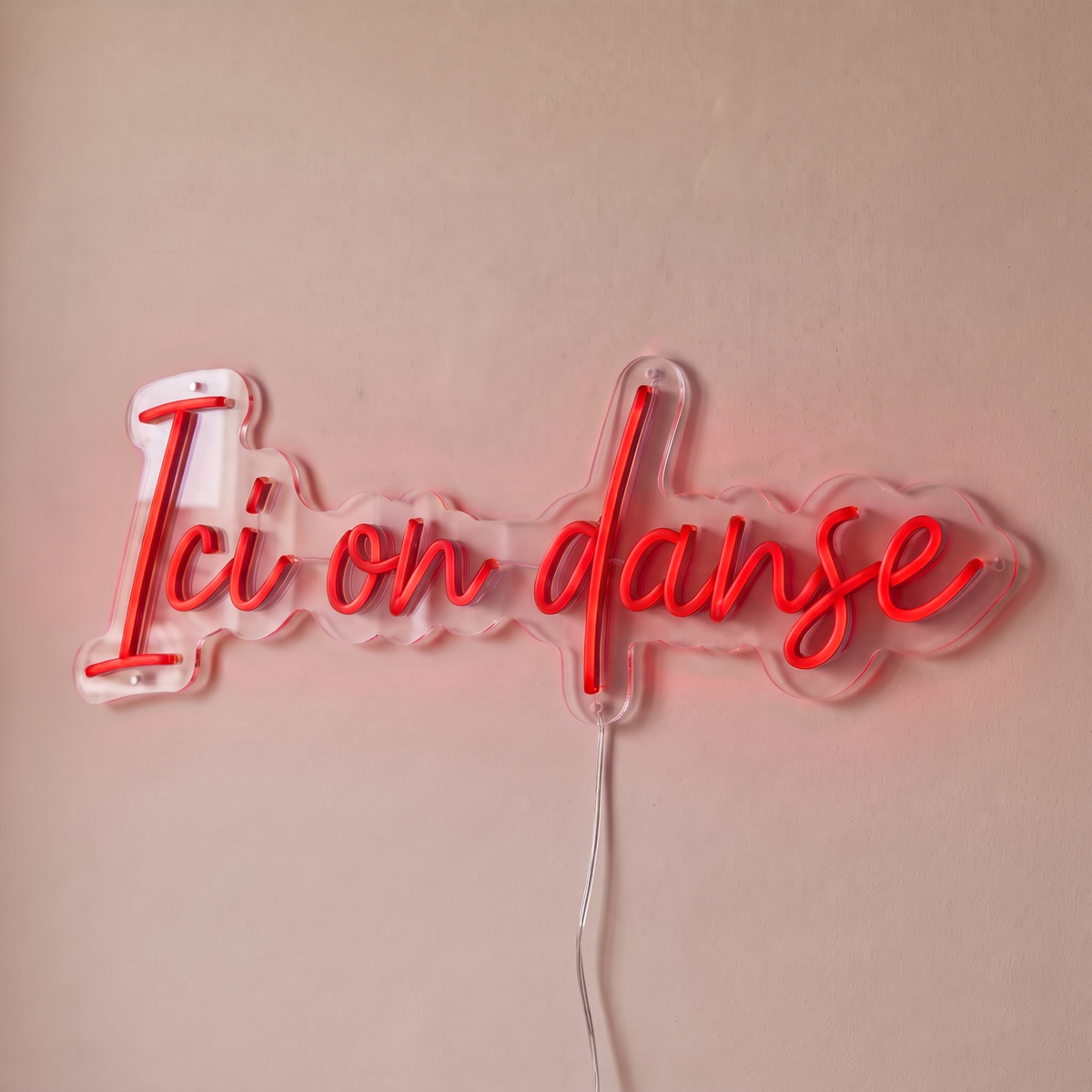 Néon mural « Ici on danse » rouge, gros plan sur fond beige