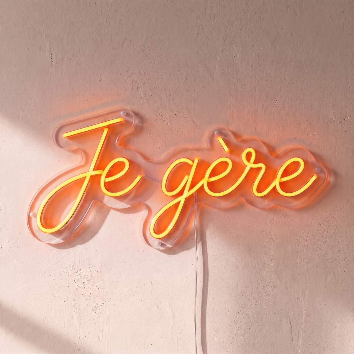 Néon mural « Je gère » orange, gros plan sur fond beige