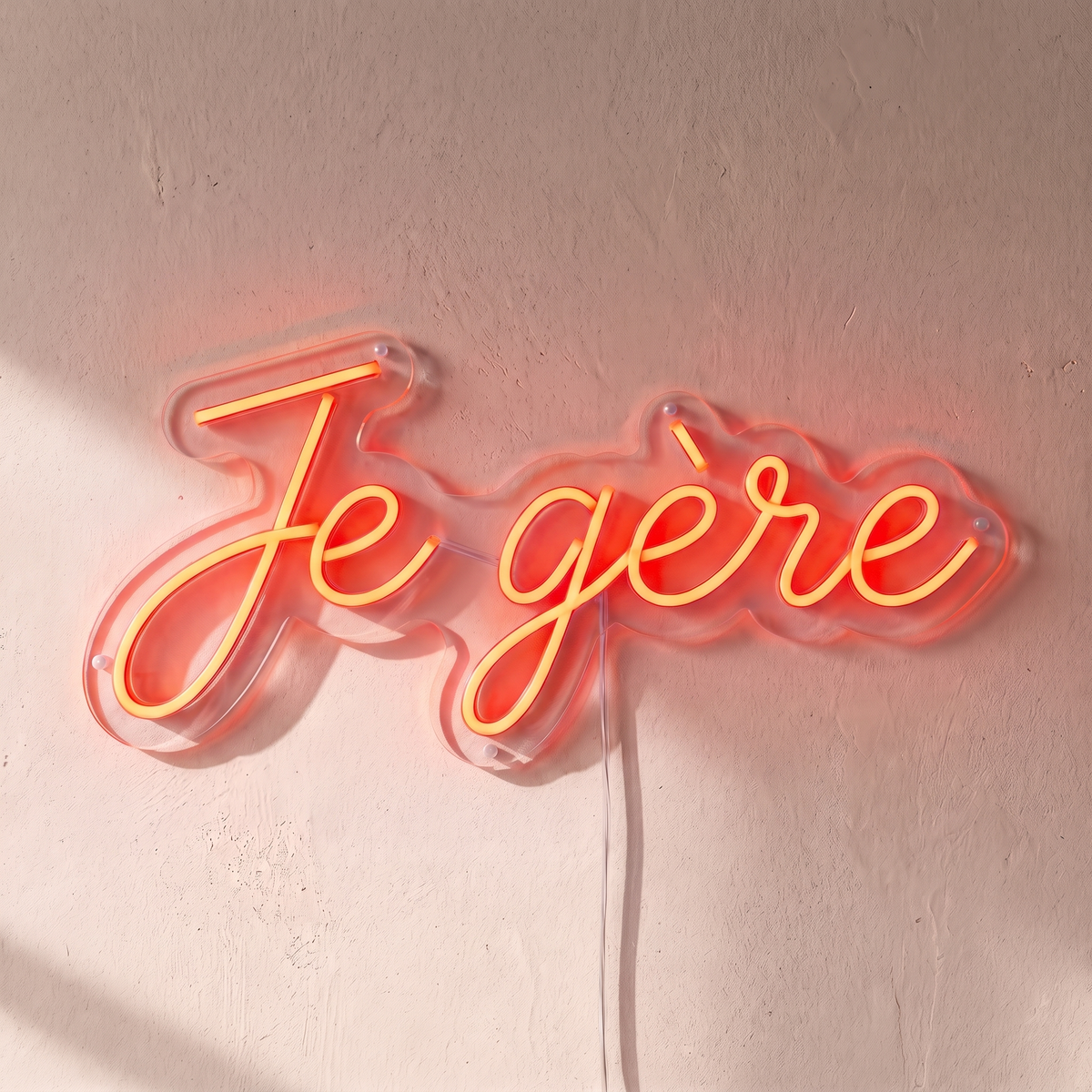 Néon mural « Je gère » rouge orangé, gros plan sur fond beige