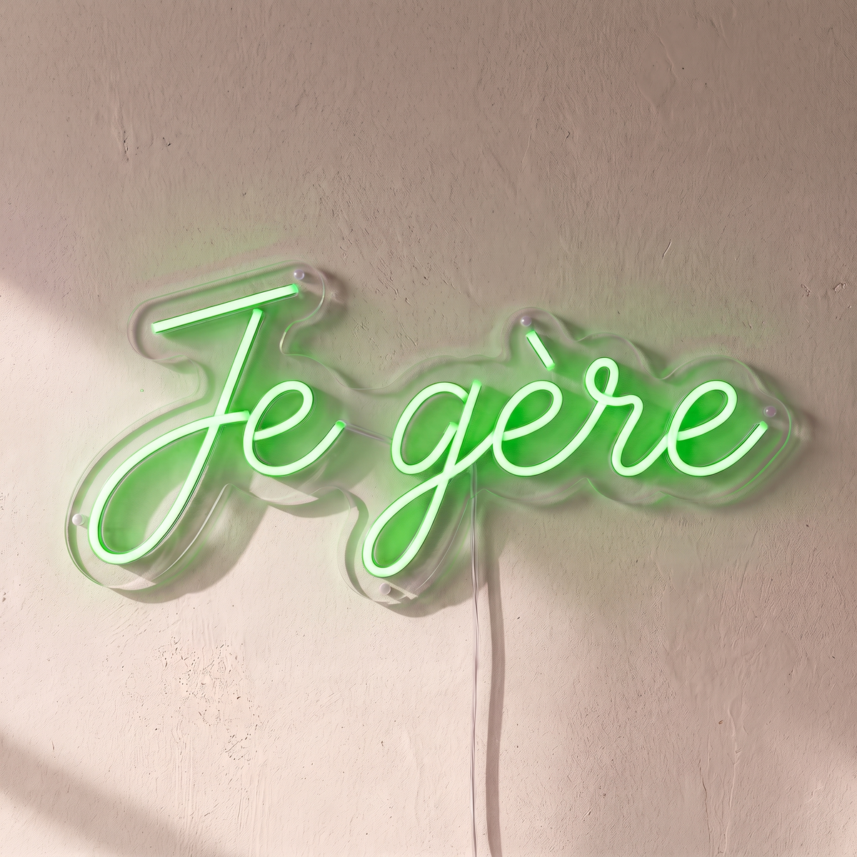 Néon mural « Je gère » vert, gros plan sur fond beige
