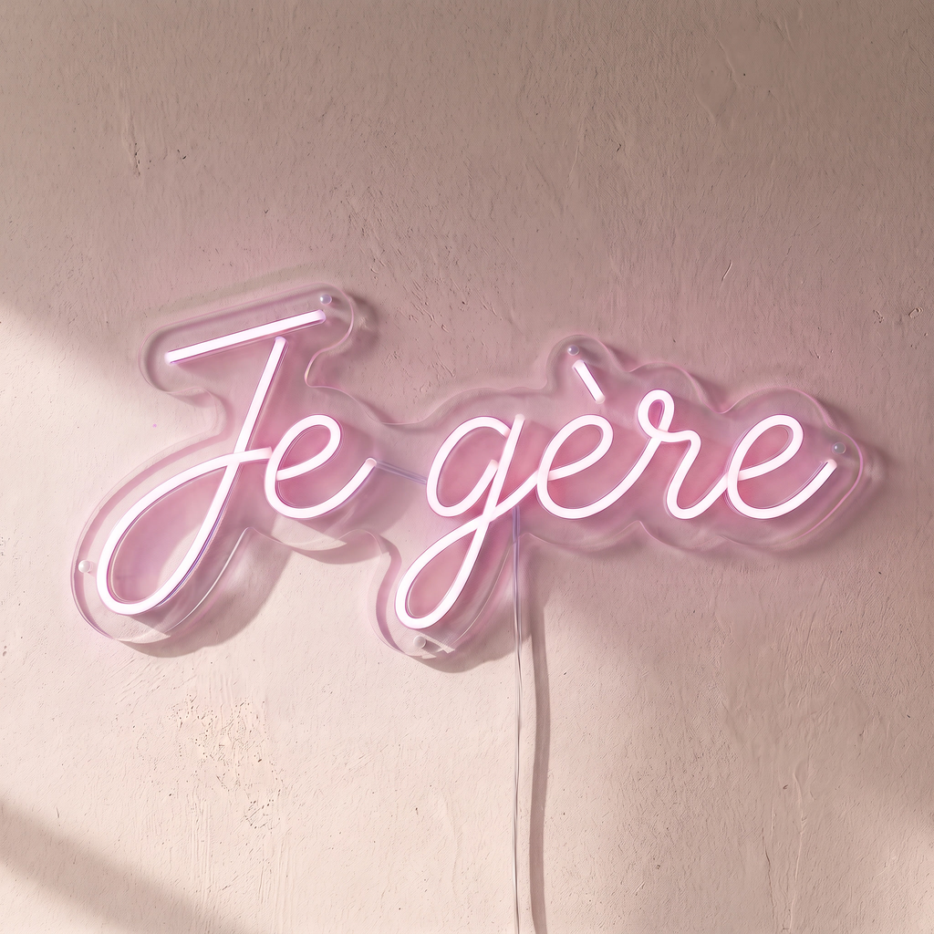 Néon mural « Je gère » rose pâle, gros plan sur fond beige